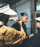 Person getting their hair styled by another person in a salon setting.