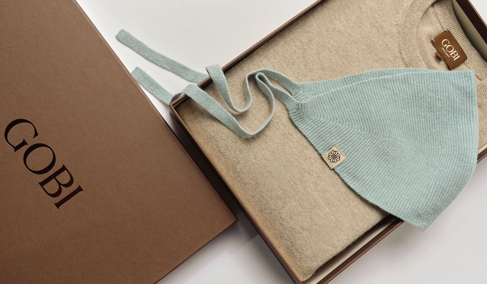Light blue baby hat with beige fabric and 'Gobi' branding on a white background