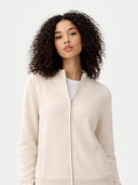 Woman wearing a beige zip-up sweater against a white background #color_off-white