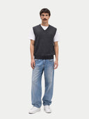 front view of Man wearing a dark gray vest over a white shirt, light blue jeans, and white sneakers on a white background #color_charcoal