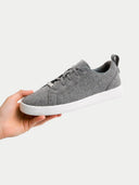 Gray sneaker held by a hand on a white background #color_stone-gray