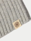 close up of gray knit beanie with a brand tag on a white background #color_high-rise