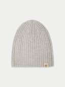 Gray knit beanie with a brand tag on a light gray background #color_high-rise