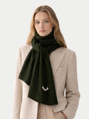 Woman wearing a green scarf with a beige coat on a light gray background #color_capulet-olive