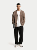 Man wearing a brown cardigan, white shirt, black pants, and gray gloves on a white background #color_dim-gray