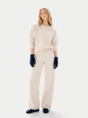 Woman wearing a beige sweater and pants with navy gloves on a white background #color_navy-blazer