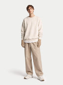 Man wearing a beige sweater and pants with gloves on a white background #color_taupe