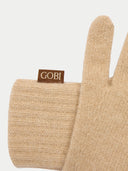 close up of a beige glove with a Gobi brand tag on a light gray background #color_beige
