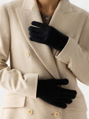 Person wearing a beige coat and black gloves on a white background #color_black