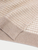 Close-up of a beige knitted sweater with a textured pattern on a white background #color_warm-grey