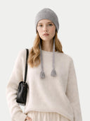 Woman wearing a gray knit beanie with tassels on a white background #color_dim-gray