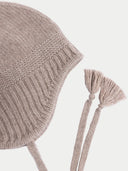Knitted baby bonnet with tassels on a light background #color_taupe