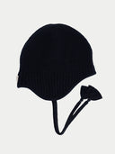 Black knit earflap hat on a light gray background #color_black