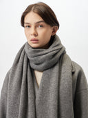 A woman wearing a lightweight cashmere shawl in a gray color, draped over her shoulders. #color_dim-gray