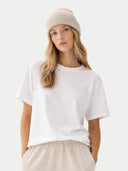 Person wearing a white t-shirt and beige beanie on a plain background #color_beige