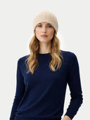 Woman wearing a navy sweater and beige beanie on a white background #color_beige