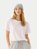 Woman wearing a white t-shirt and gray pants on a plain background #color_high-rise