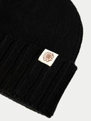 Black beanie with a logo patch on a white background #color_black