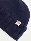 Navy blue knit beanie with a brand logo on a white background #color_navy-blazer