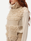 close up of a beige loop-stitch gilet with fringe detail. #color_warm-grey
