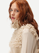 A woman wearing a beige loop-stitch gilet  #color_warm-grey