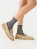 side view of beige flats, pair of ribbed socks worn by a person.