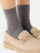 close up of beige flats, pair of ribbed socks worn by a person.