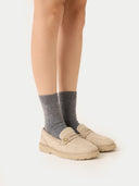 side view of a person wearing gray socks and beige shoes on a white background #color_dim-gray