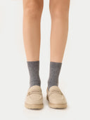front view of a person wearing gray socks and beige shoes on a white background #color_dim-gray