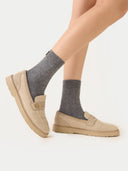 Person wearing gray socks and beige shoes on a white background #color_dim-gray