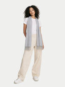 Woman wearing a light gray scarf, white shirt, beige pants, and white sneakers on a white background #color_vapor-blue