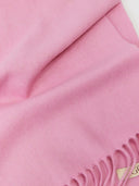 Close-up of a pink fabric with fringes and a brand label. #color_sweet-lilac