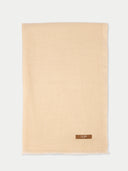 Beige scarf with a brand label on a white background.