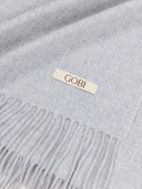 close up of gray scarf with a 'Gobi' label on a light gray background #color_high-rise