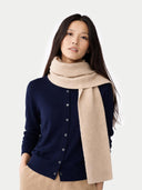 Woman wearing a navy cardigan and beige scarf on a white background #color_beige