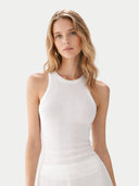 Woman wearing a white sleeveless top against a light gray background #color_whisper-white