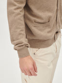 close up of a brown cardigan with button, side pockets and beige pants #color_taupe