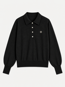 A black long-sleeve knit polo shirt with a three-button placket and a small circular embroidered logo on the left chest, displayed on a light gray background.