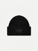 A black ribbed knit beanie hat with a folded cuff, featuring the brand name 'GOBI' and 'EST. 1981' embroidered in a dark gray tone on the front, set against a plain light gray background.