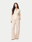 Woman wearing a beige cardigan and pants on a white background #color_off-white
