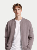 Man wearing a gray jacket over a white shirt on a light gray background #color_stucco