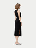 back view of a woman wearing a black sleeveless long dress on a white background #color_black