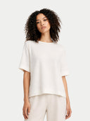 Woman wearing a white top and pants on a white background #color_whisper-white