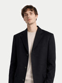 close up of a Man wearing a black coat over a light shirt on a white background #color_black