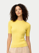 Woman wearing a yellow short-sleeve top against a light gray background #color_blazzing-yellow