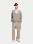 Man wearing a gray cardigan, beige turtleneck, and beige pants on a white background #color_dawn-blue