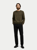 front view of a man wearing a green sweater and black pants on a white background #color_burnt-olive