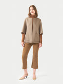 Woman wearing a beige jacket and pants on a white background. #color_taupe