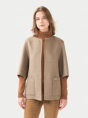 Woman wearing a beige coat with a white background. #color_taupe