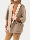 Person wearing a beige blazer over a brown turtleneck and pants on a white background. #color_taupe